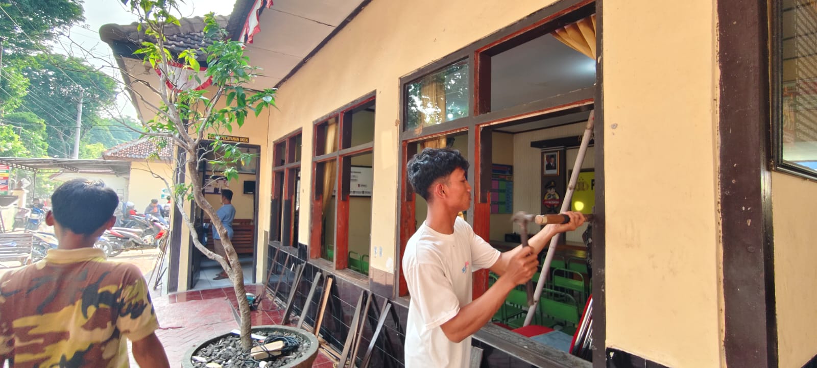 MULAI DIPERBAIKI &ndash; Seorang pekerja sedang memperbaiki jendela kaca Mapolsek Purwodadi yang rusak aksi anarkis pada Sabtu (30/8) kini mulai diperbaiki hari ini.