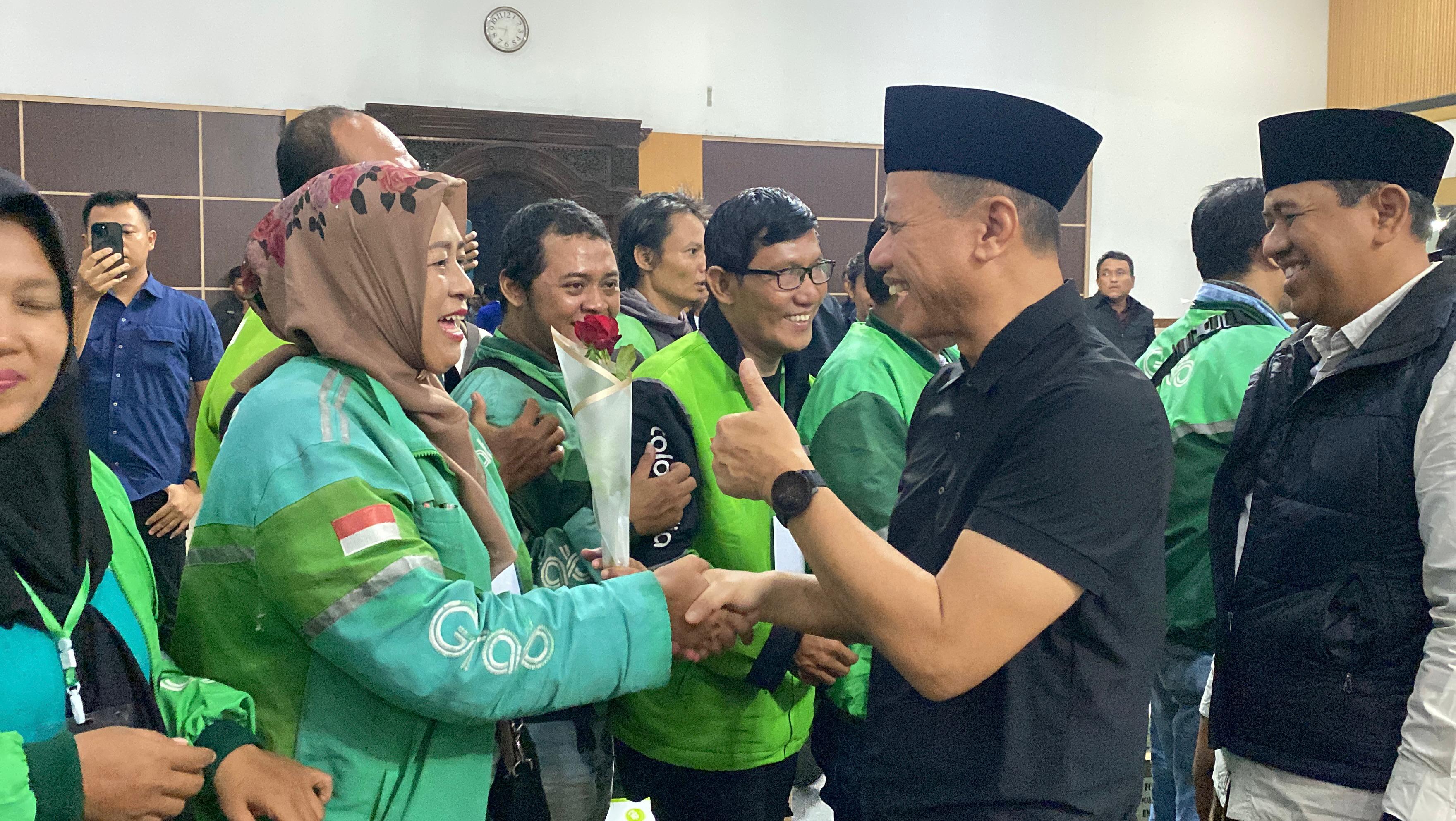 JABAT TANGAN: Bupati Kudus, Sam&rsquo;ani Intakoris bersalaman dengan seluruh komunitas ojol yang hadir usai acara di Gedung DPRD Kudus, malam ini. (ANDIKA TRISNA SAPUTRA/RADAR KUDUS)