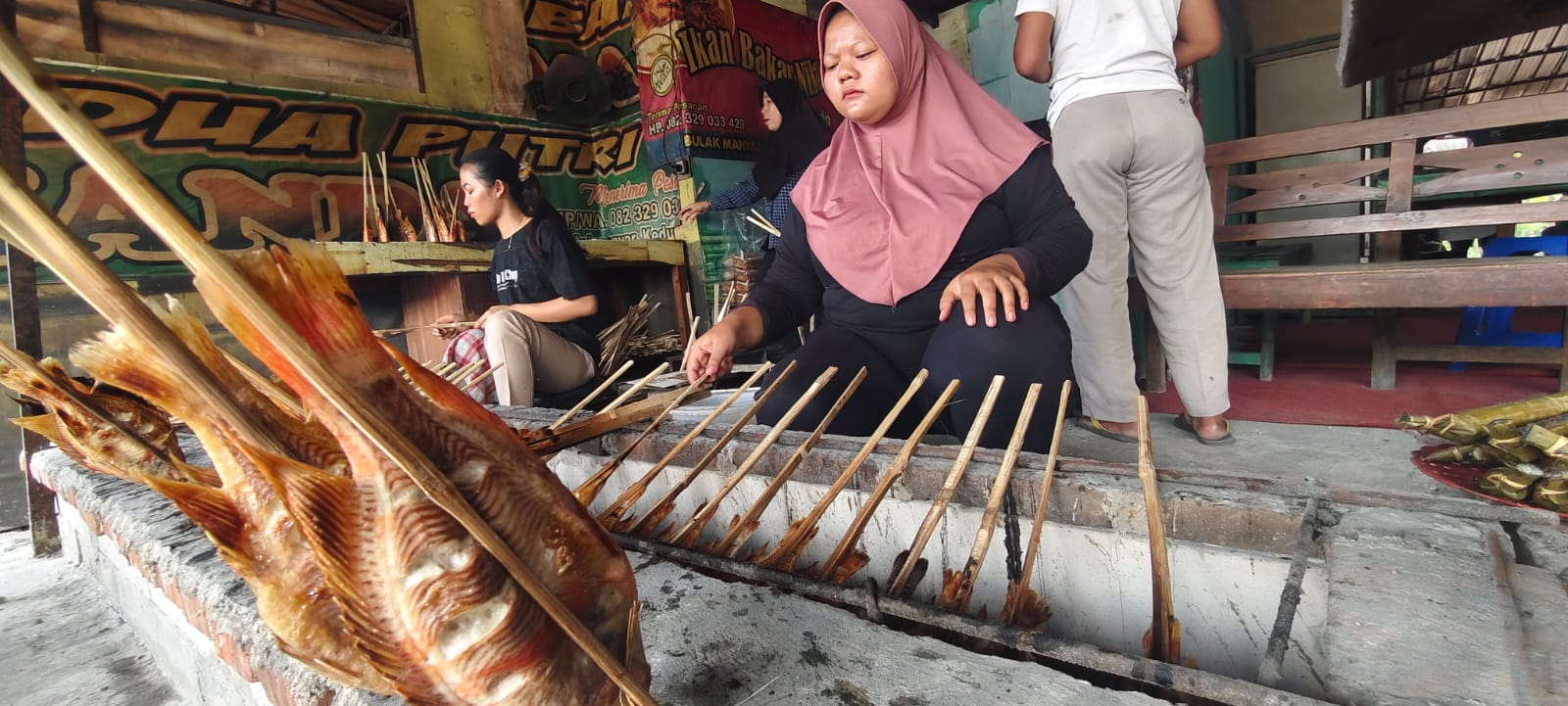 DIBAKAR ASAP &ndash; Berjejer ikan Nila sedang dibakar asap oleh pemilik warung di sekitar Waduk Kedungombo, Desa Rambat, Kecamatan Geyer, Grobogan.