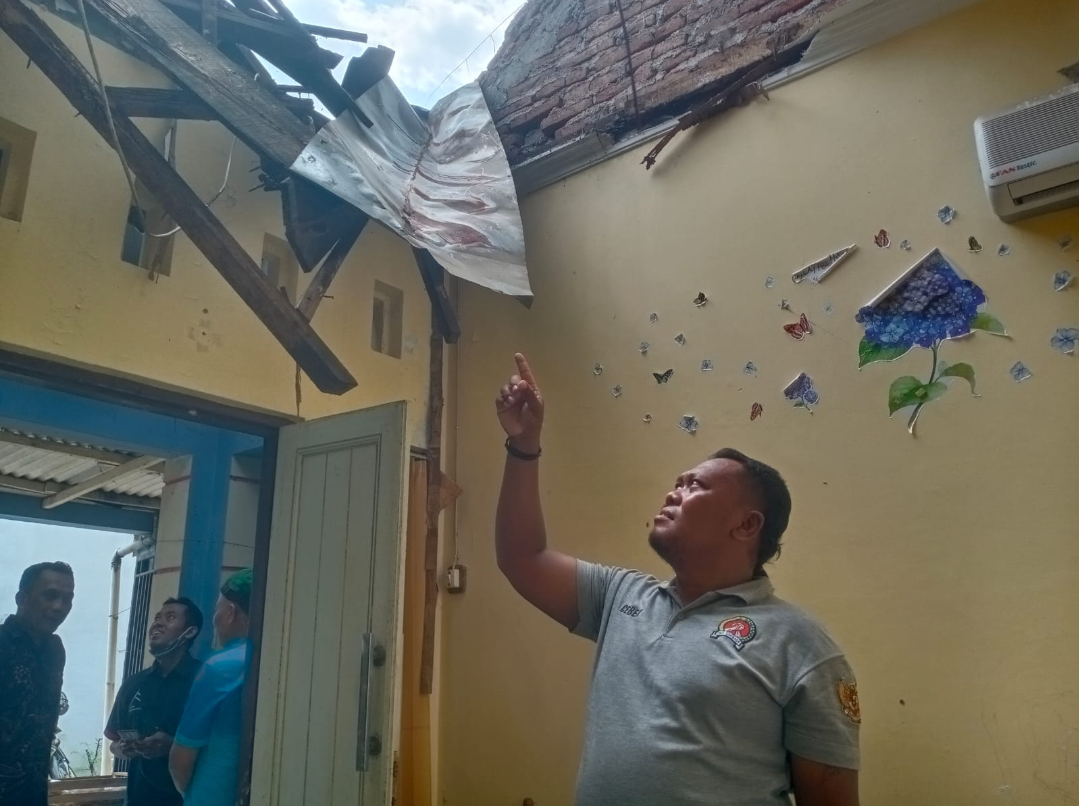 AMBROL: Salah satu warga menunjukkan kerusakan rumah tetangganya yang roboh, Jumat (12/9). (ANDIKA TRISNA SAPUTRA/RADAR KUDUS)