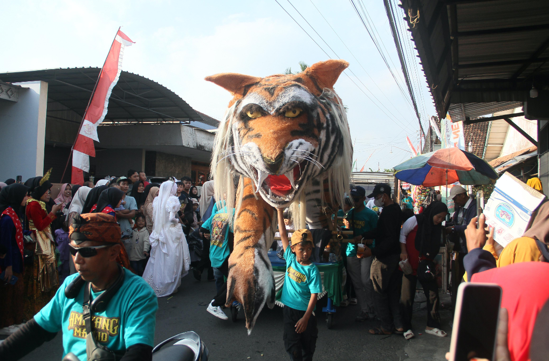 KREATIF: Masyarakat menyalurkan kreatifitasnya dengan membuat patung macan dalam kirab Festival Ampyang Maulid, belum lama ini. (GALIH ERLAMBANG W/RADAR KUDUS)