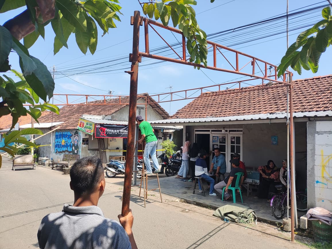BERKABUNG: Warga memasang tenda di depan rumah korban yang berlokasi di Kelurahan Wergu Wetan.