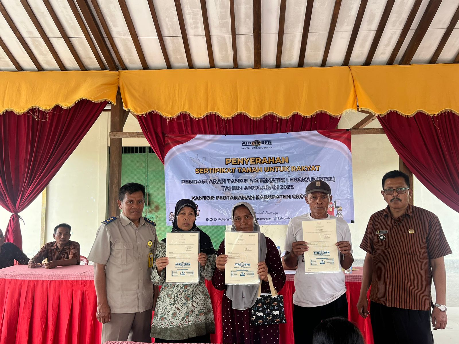 DISERAHKAN: Kantah Grobogan saat menyerahkan sertifikat tanah PTSL di Desa Tuko Kecamatan Pulokulon.