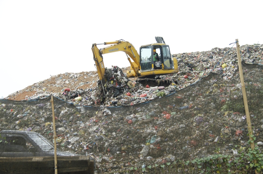 MENUMPUK: Petugas tengah melakukan penataan sampah di TPA Bandengan dengan sistem landfill pada Rabu (17/9).