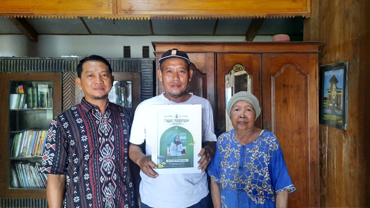 BANGGA: Perangkat Desa Putatsari (kiri), Kholid Almujjahidin (Kakak sepupu) dan Musripah (budhe) saat menunjukkan foto Farida Farichah di rumahnya.