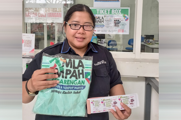 BURUAN SEBELUM KEHABISAN: Bagian Admin Radar Kudus Septa Juwanti menunjukkan kaus dan tiket &rdquo;Mlampah Sesarangan Menuju Kudus Sehat&rdquo; di kantor Jawa Pos Radar Kudus kemarin.