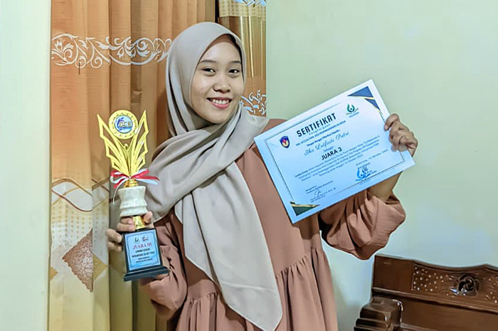 BANGGA: Ika Lutfiati Putri menunjukkan piala dan sertifikat juara tiga lomba essay tingkat nasional, belum lama ini.