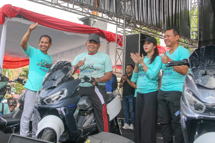 BERUNTUNG: Panoto menerima hadiah utama Mlampah Sesarengan Bupati-Wabup Kudus Menuju Kudus Sehat berupa sepeda motor Listrik Polytron.