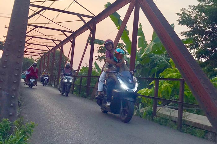LINTAS: Rute Scooter Go Green, jembatan merah yang sedang dilalui pengendara motor di sore hari, Jumat (26/9).