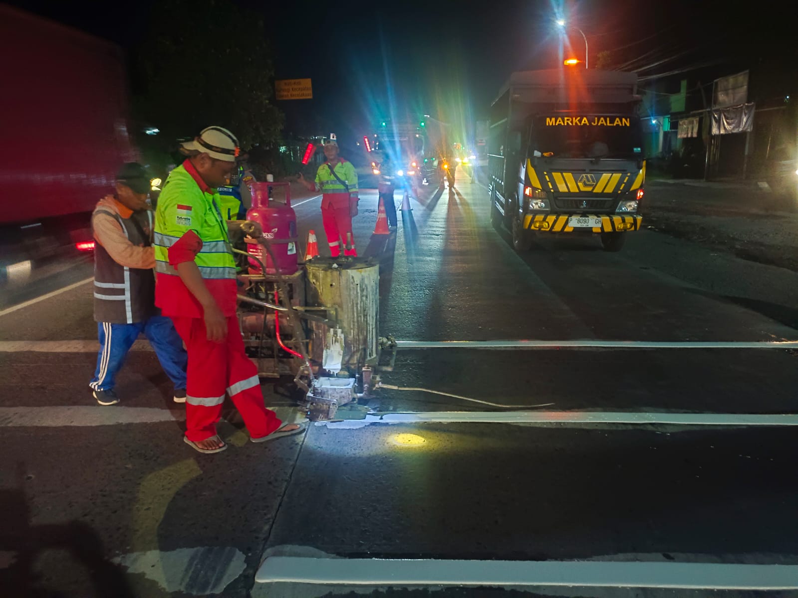 DITANGANI: Pekerja memberikan pita kejut di ruas jalan yang ada di Kabupaten Kudus.  &nbsp;