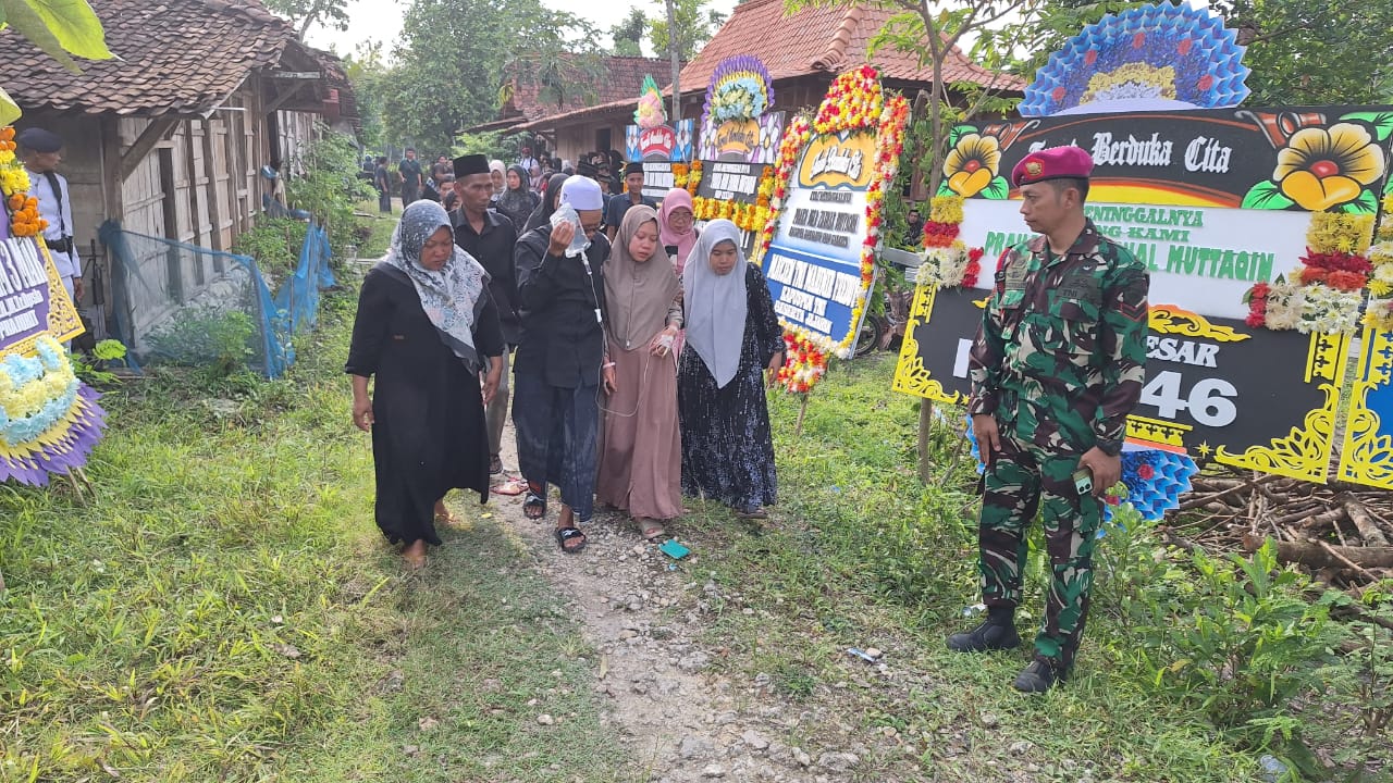 Istri prajurit Marinir, Praka Zaenal Mutaqin yang sedang mengandung 7 bulan memakai baju coklat sedang menangis tersedu saat pemakaman suami tercinta
