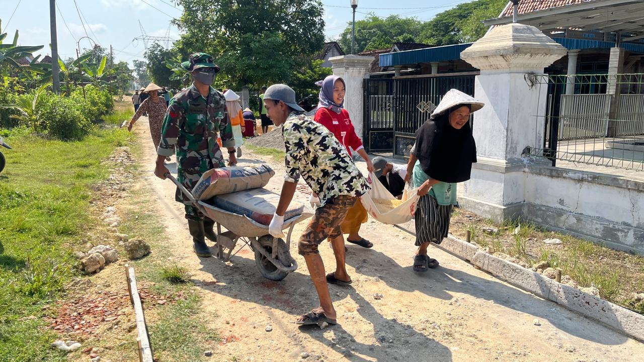 GOTONG ROYONG: Warga dan TNI saat bahu membahu mengerjakan rabat beton di TMMD Reguler Desa Karangharjo Kecamatan Pulokulon.