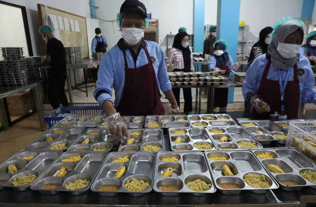 SIAPKAN: Pekerja tampak sibuk menyiapkan makanan yang akan dibagikan untuk program MBG, belum lama ini. (SPPG JATI UNTUK RADAR KUDUS)