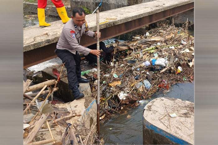 Bhabinkamtibmas Polsek Kalinyamatan jajaran Polres Jepara Aipda Jaka Priyana&nbsp; melaksanakan kerja bakti bersihkan sungai Kaweden, Kamis (23/10).