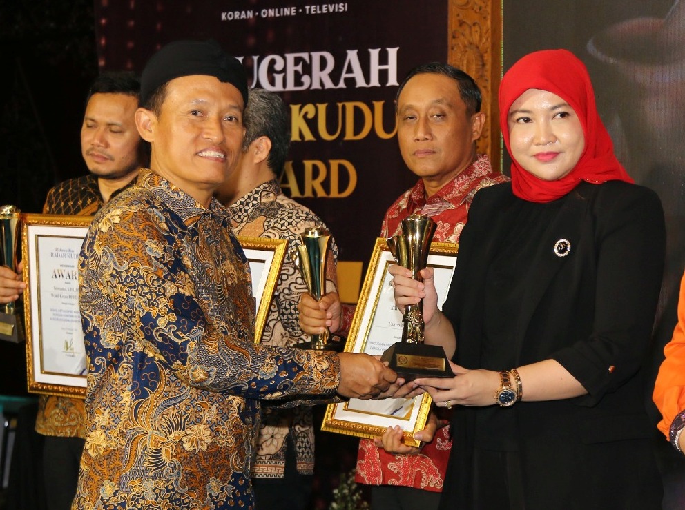 JADI MOTIVASI: Vivit Dinarini Atnasari, putri Owner PT Bhina Group Atna Tukiman  piala Radar Kudus Award dari Dirut Jawa Pos Leak Kustiya.