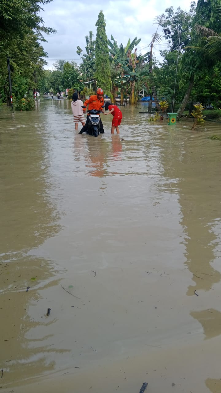 BANJIR: Petugas BPBD Grobogan saat membantu warga yang melintas di lokasi banjir.