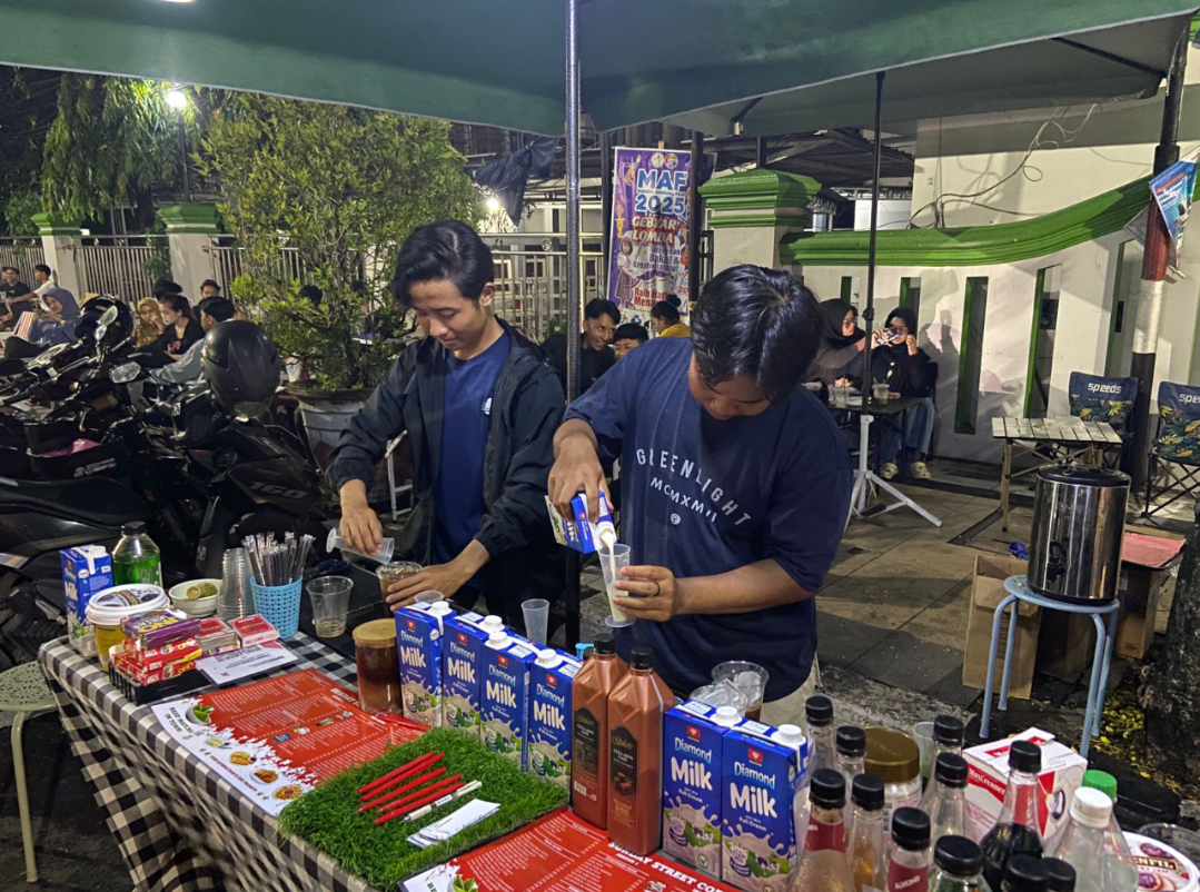TAKAR RASA: Dua orang peracik kopi sedang membuat kopi pesanan pelanggan di salah satu street coffee di Jalan Jenderal Sudirman, kemarin. (ANDIKA TRISNA SAPUTRA/RADAR KUDUS)
