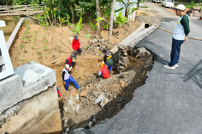 CEK KERUSAKAN: Petugas membenarkan jembatan ambrol di Desa Pelemgede, Pucakwangi kemarin.