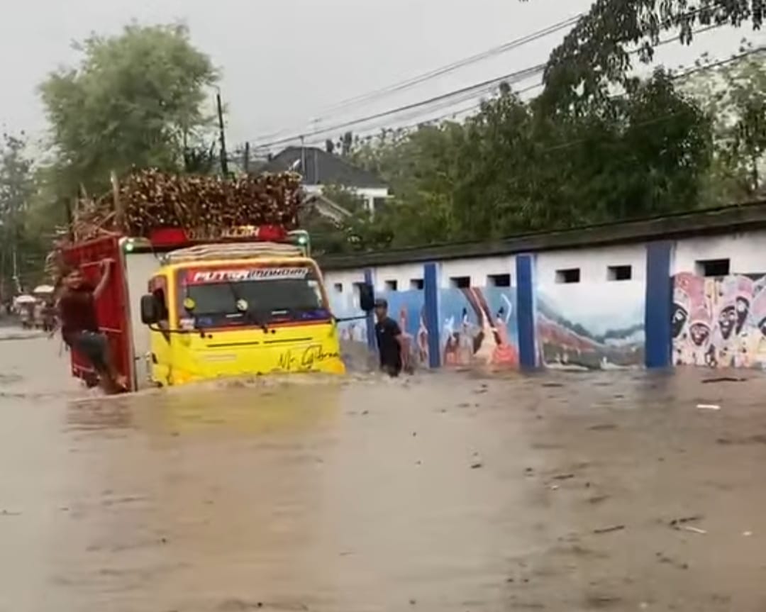NEKAT: Sebuah truk bermuatan tebu nekat menerjang banjir di Jalan Raya Sumber-Kaliori kemarin sore.