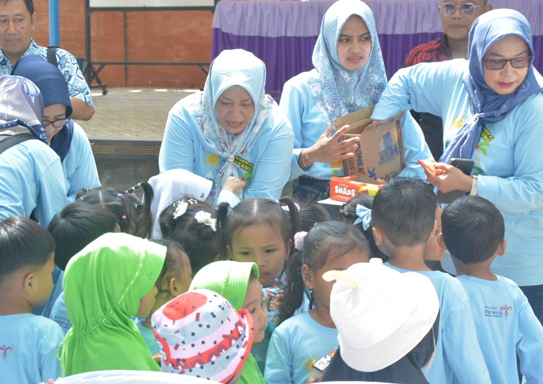 BAGIKAN SUSU: Bunda PAUD Kabupaten Rembang Musringah Harno (membukuk) membagikan susu kepada anak-anak PAUD dan TK yang hadiri mengikuti kegiatan di Pantai Karang Jahe kemarin.