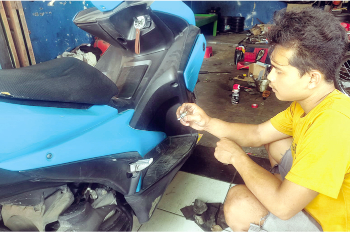 GANTI BUSI: Mekanik menujukan busi motor yang sudah tidak berfungsi, karena diduga akibat bahan bakar yang digunakan bercampur air.