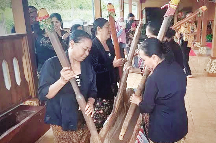 WISATA BUDAYA: Sejumlah wisatawan mencoba menumbuk padi dengan peralatan tradisional.