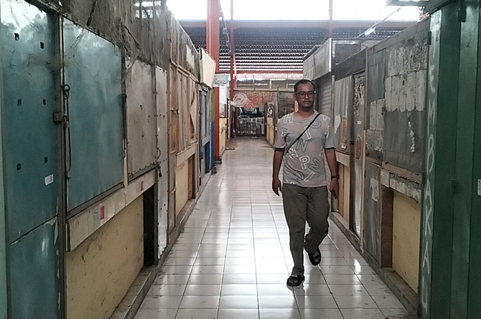 PASAR SEPI: Pengunjung saat melintas di area kios pedagang Pasar Sido Makmur Blora yang tutup.