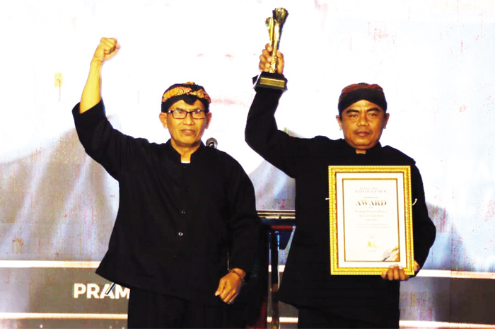 KEREN: Warso Suparyono anak dari Pramugi Prawiro Wijoyo saat menerima penghargaan Jawa Pos Radar Kudus Award yang diserahkan secara langsung oleh Direktur Jawa Pos Radar Kudus Baehaqi.