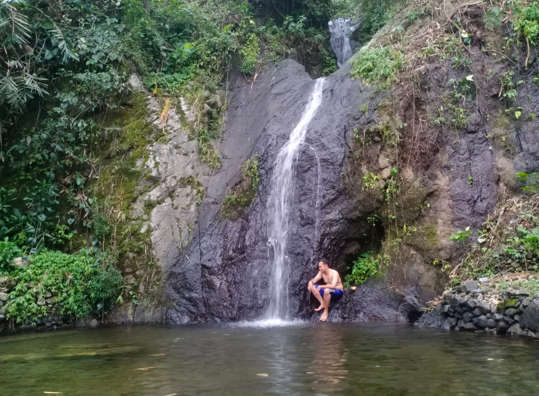 SEJUK: Pengunjung sedang menikmati harinya dengan bersantai dan merasakan sejuknya air di Air Terjun Kalibanteng, kemarin. (ANDIKA TRISNA SAPUTRA/RADAR KUDUS)