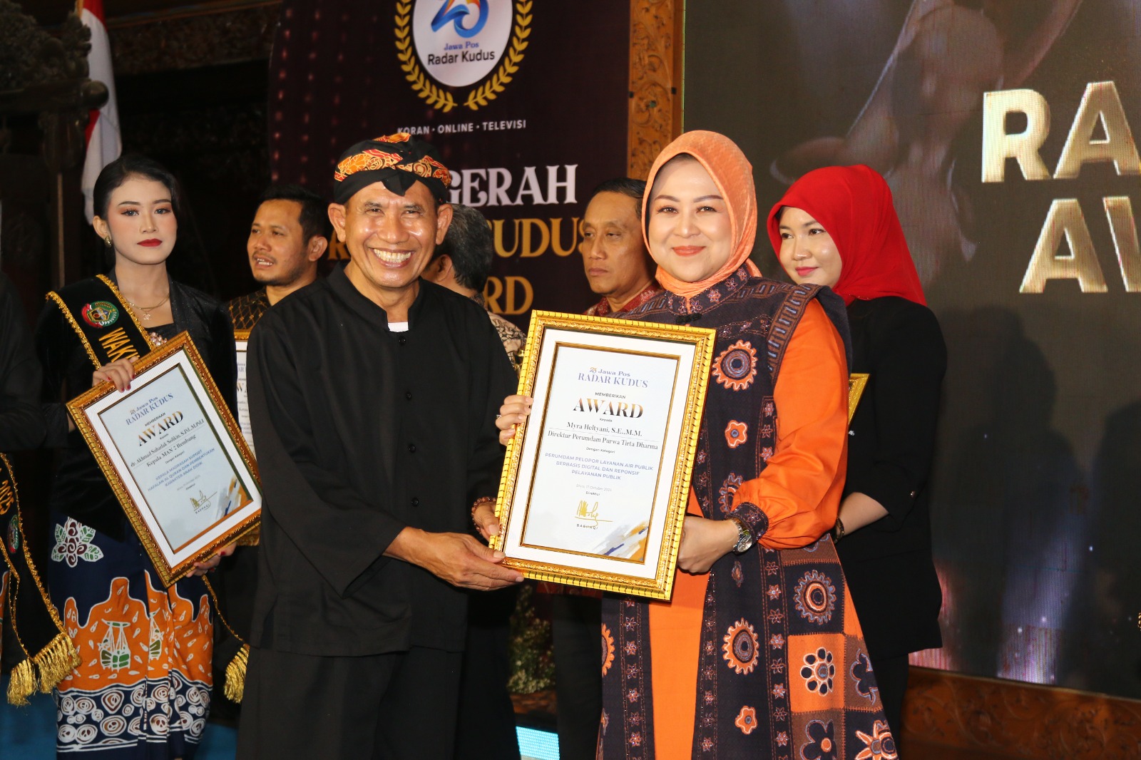 PELAYANAN TERBAIK &ndash; Direktur Radar Kudus Baehaqi menyerahkan piagam Radar Kudus Award Tahun 2025 kepada Direktur Utama Purwa Tirta Dharma Grobogan Myra Heltiyani di Pendopo Kabupaten Blora.