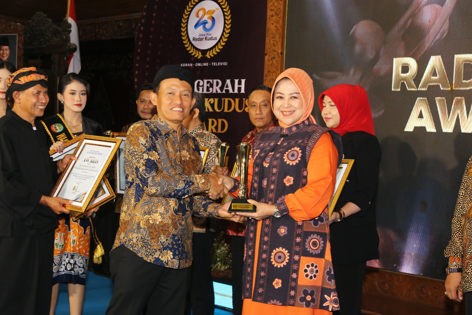 TERIMA PENGHARGAAN - Direktur Jawa Pos Koran Leak Kustiya menyerahkan piala Radar Kudus Award Tahun 2025  kepada Direktur Utama Purwa Tirta Dharma Grobogan Myra Heltiyani di Pendopo Kabupaten Blora