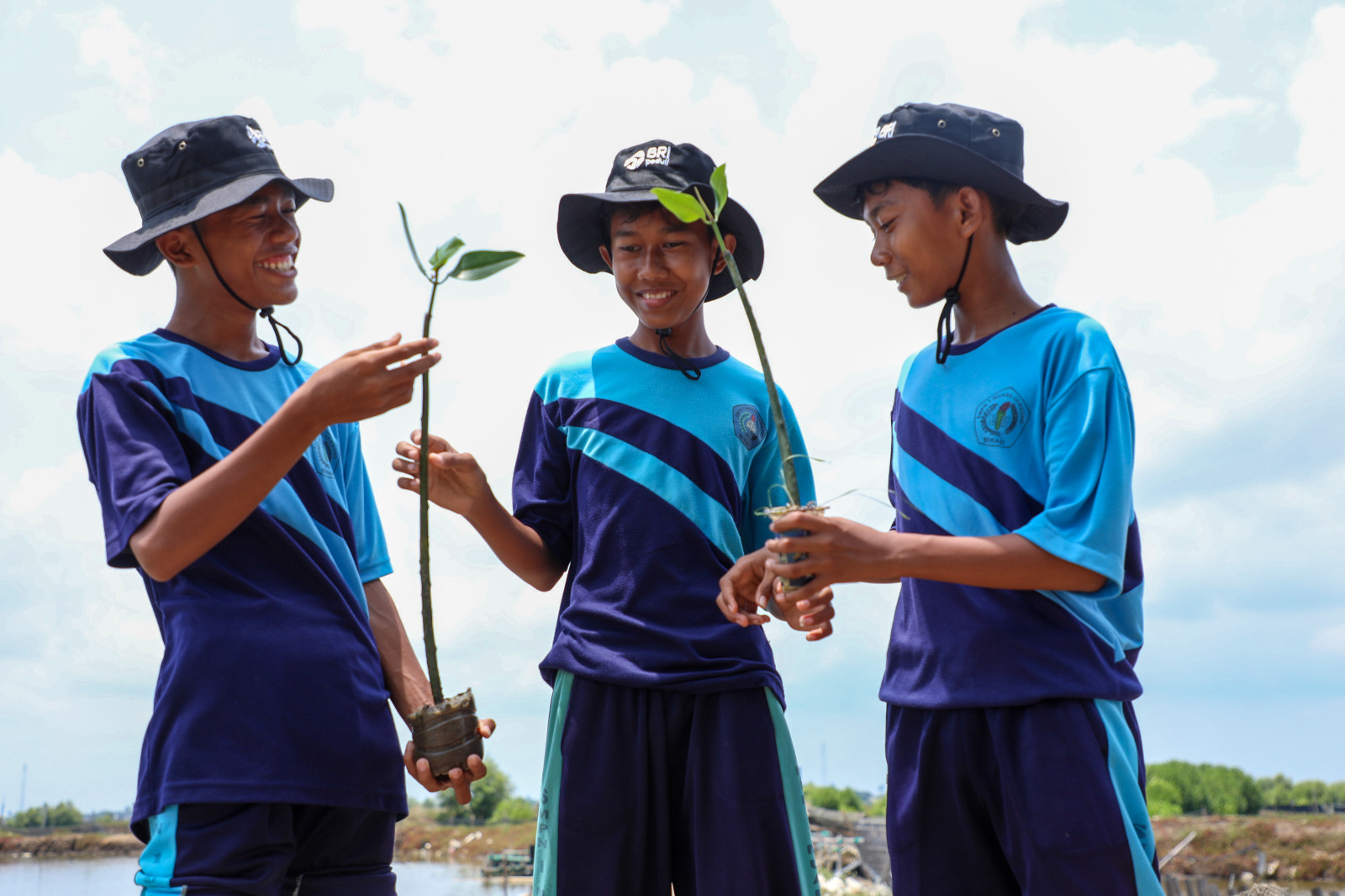 Ilustrasi foto Siswa SMP Negeri 1 Muara Gembong membawa bibit tanaman mangrove