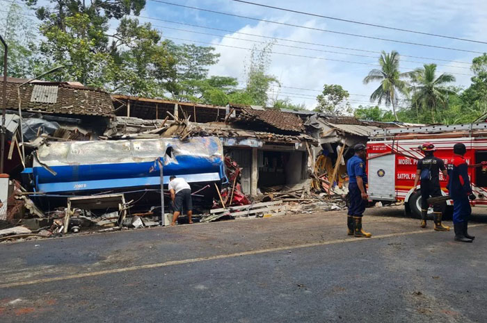 EVAKUASI: Petugas sedang mengevakuasi dan melakukan pembersihan solar di area kecelakaan, tepatnya di depan Pasar Kalijambe, Purworejo, Selasa (11/11/2025).