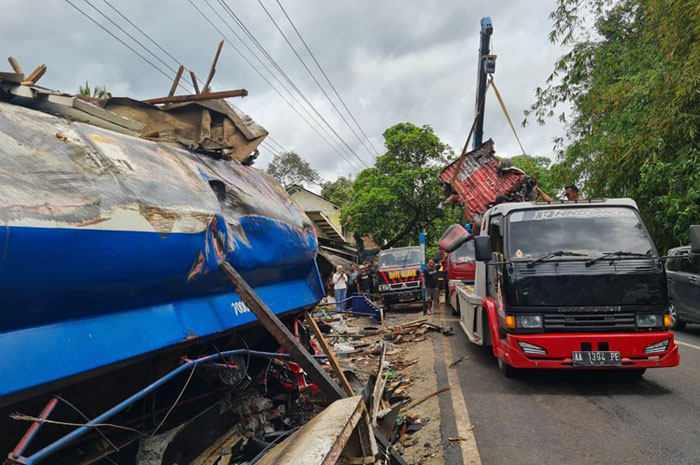 PEMBERSIHAN: Petugas gabungan berupaya mensterilkan badan jalan dan puing-puing kendaraan di depan Pasar Kalijambe, Selasa (11/11/2025).