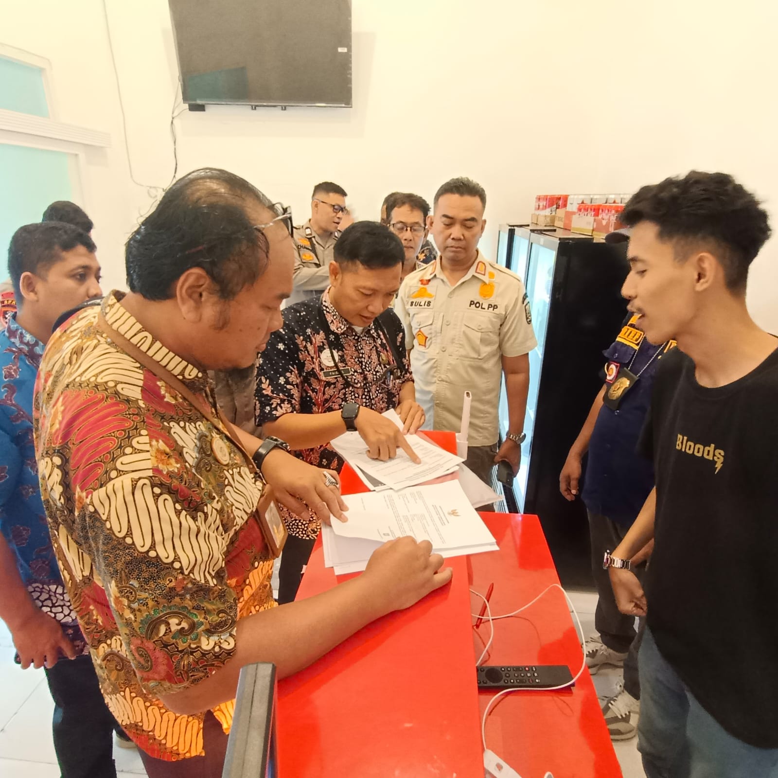 WISNU AJI/RADAR KUDUS DISITA: Petugas Satpol PP mengamankan puluhan ratusan botol berisi miras di ruko Jalan Pemuda Rembang kemarin