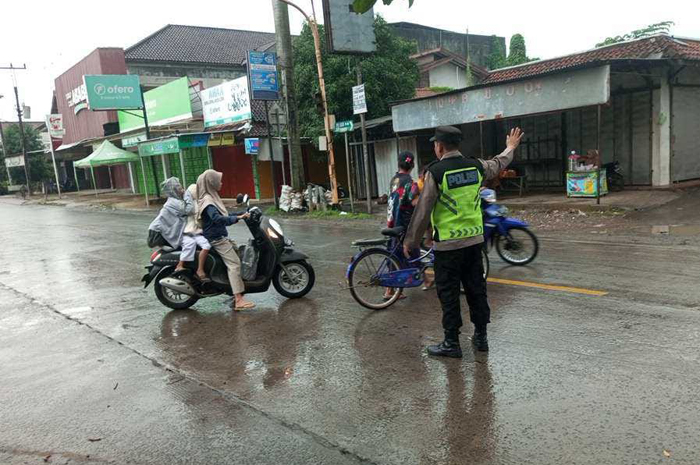 PELAYANAN MAKSIMAL: Personel Kepolisian Resor (Polres) Jepara&nbsp;sigap mengatur arus kendaraan di sejumlah titik rawan kemacetan dan genangan air meski diguyur hujan deras.