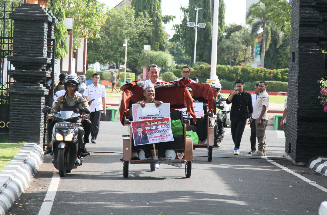 SENANG: Bupati Kudus mencoba menaiki Becak Listrik Prabowo dengan penerima sebagai penumpang di Pendopo Kabupaten Kudus, Rabu (12/11). (GALIH ERLAMBANG W/RADAR KUDUS)
