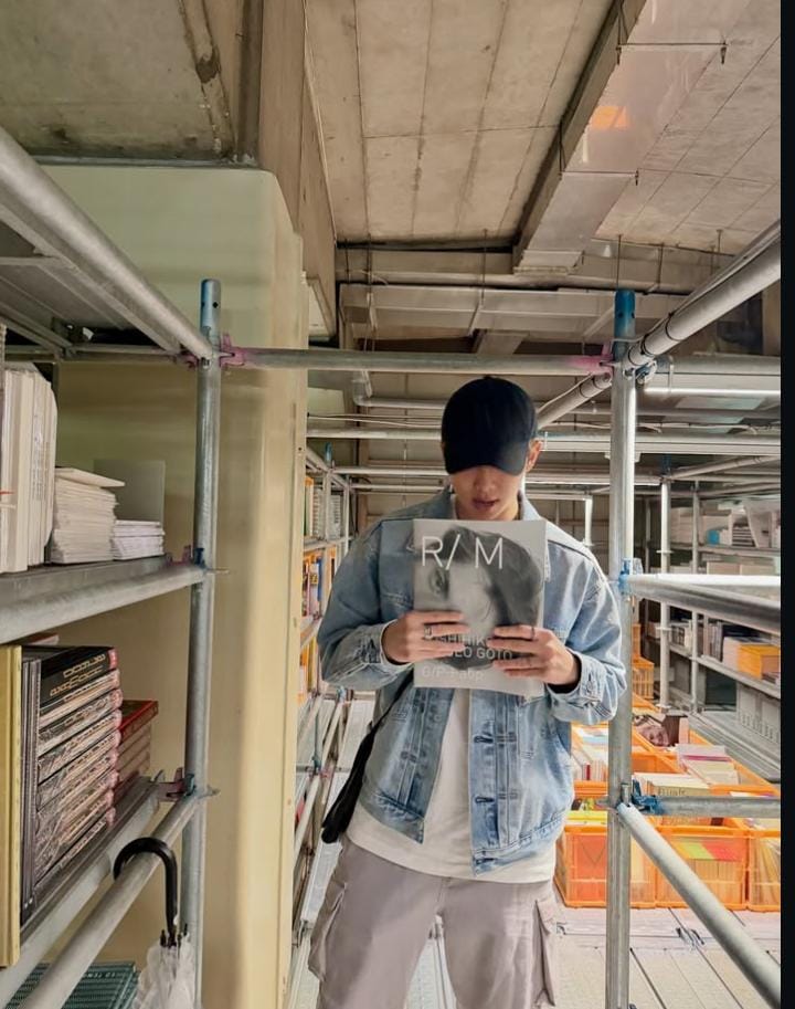 Potret RM BTS yang sedang berada di sebuah perpustakaan buku