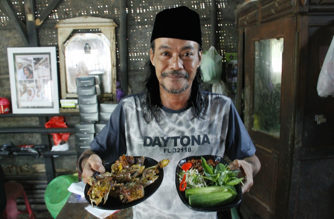 SIAP SAJI: Mas Gondrong tengah menyajikan seporsi daging dan kepala entog untuk pelanggan pada Jumat (14/11).