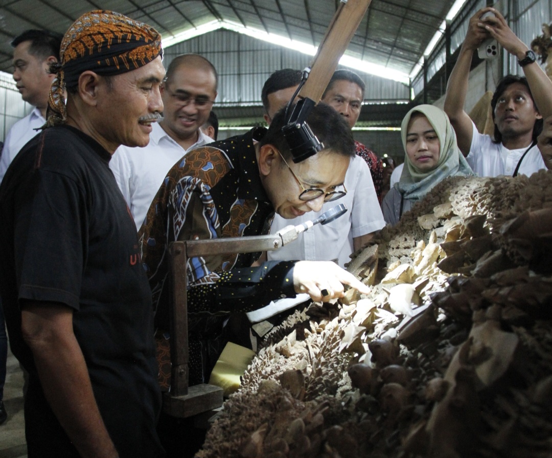 BERTAHUN-TAHUN: Menteri Kebudayaan RI Fadli Zon tengah menilik detail karya ukir ekosistem bawah laut didampingi dengan sang seniman Hartono Kasari (berblangkon) pada Sabtu (15/11).