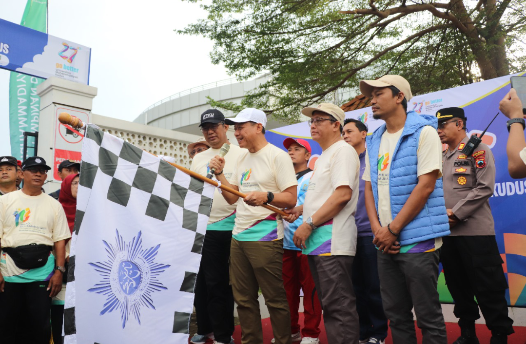 MERIAH: Bupati Kudus Sam&rsquo;ani Intakoris membuka jalan sehat dengan mengibarkan bendera start di halaman Crystal Building UMKU, Minggu (16/11). (ANDIKA TRISNA SAPUTRA/RADAR KUDUS)