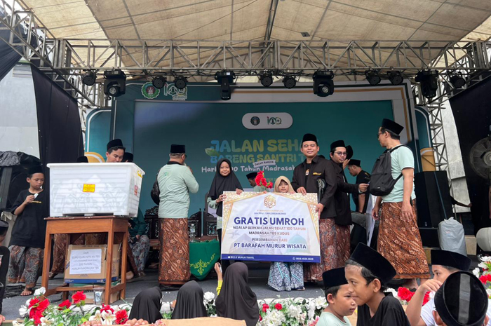 BAKTI UNTUK MADRASAH: KH Ahmad Bahruddin bersama putrinya ikut hormat dan ngalap berkah dengan menjadi donator umroh dan motor Listrik. Peraih umroh bernama Najma Talita S siswi PAUD TBS Kudus.