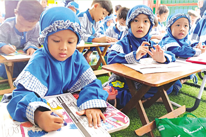 FOKUS: Anak-anak TK IT Permata Mulia tampak fokus mewarnai gambar dengan media koran koran kemarin.