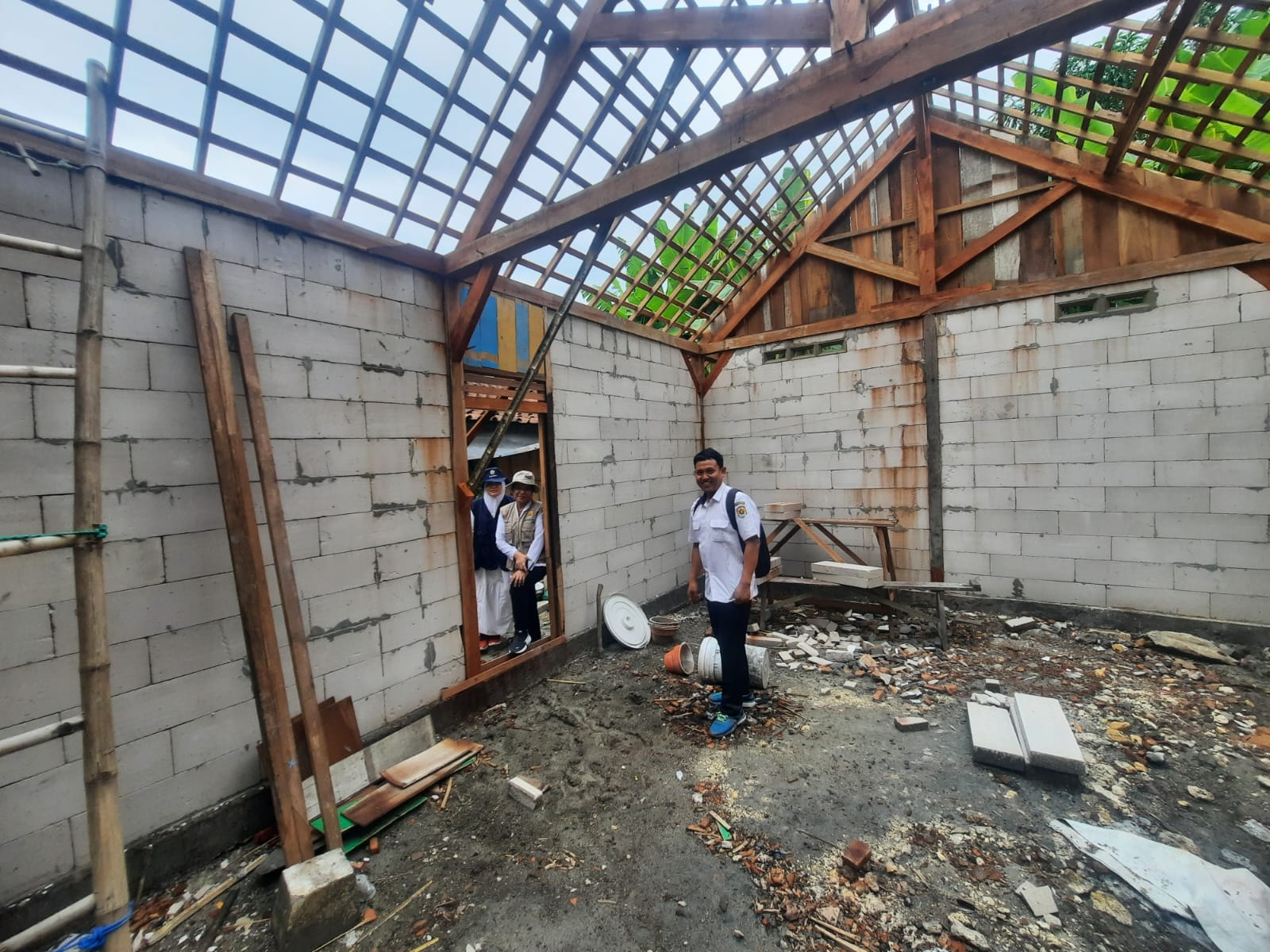 MENINJAU: Petugas Disperakim Grobogan saat mengecek lokasi rehab RTLH.