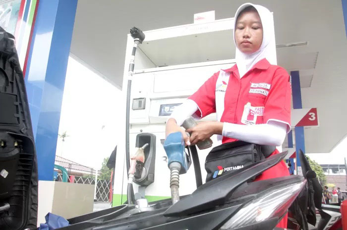 Petugas SPBU mengisi pertamax ke motor pembeli .&nbsp;