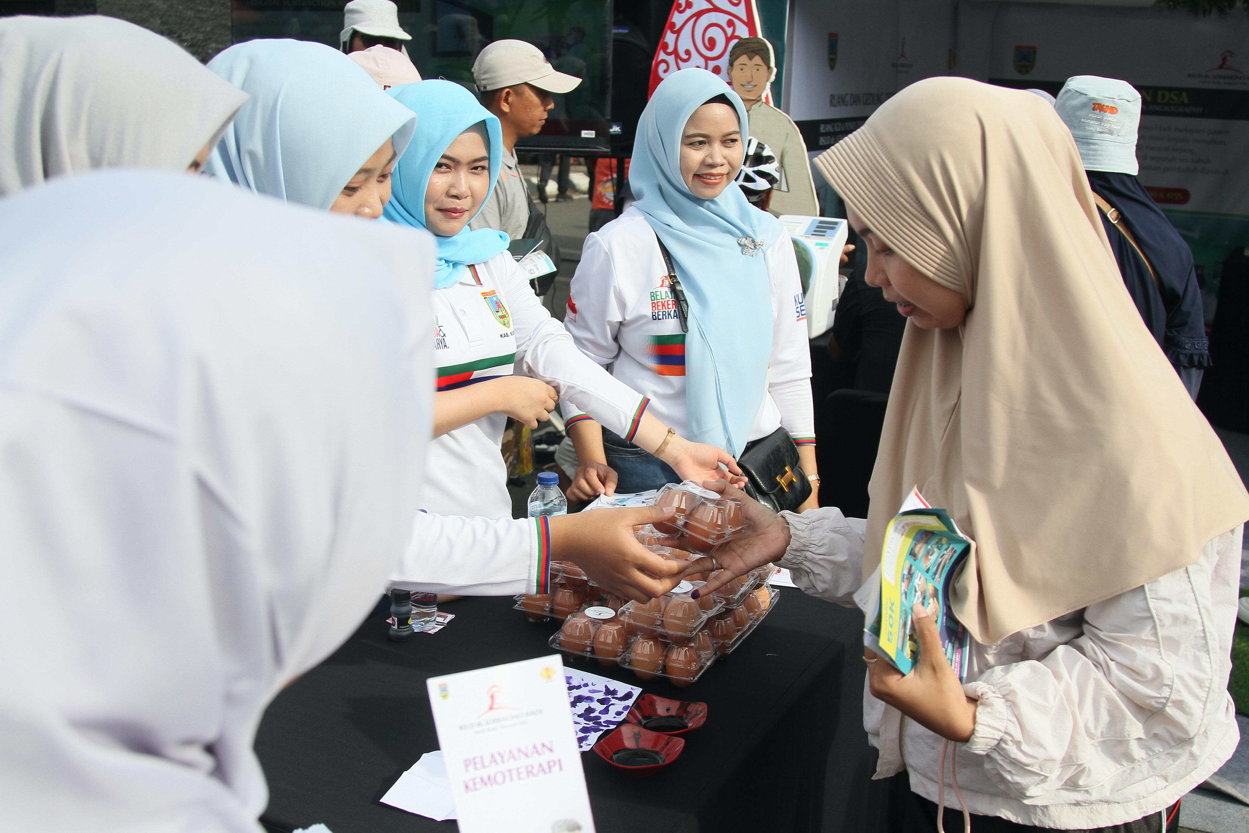 UNTUK SEHAT: Warga menerima telur gratis usai mengikuti cek kesehatan gratis yang diselenggarakan RSUD dr. Loekmono Hadi Kudus.