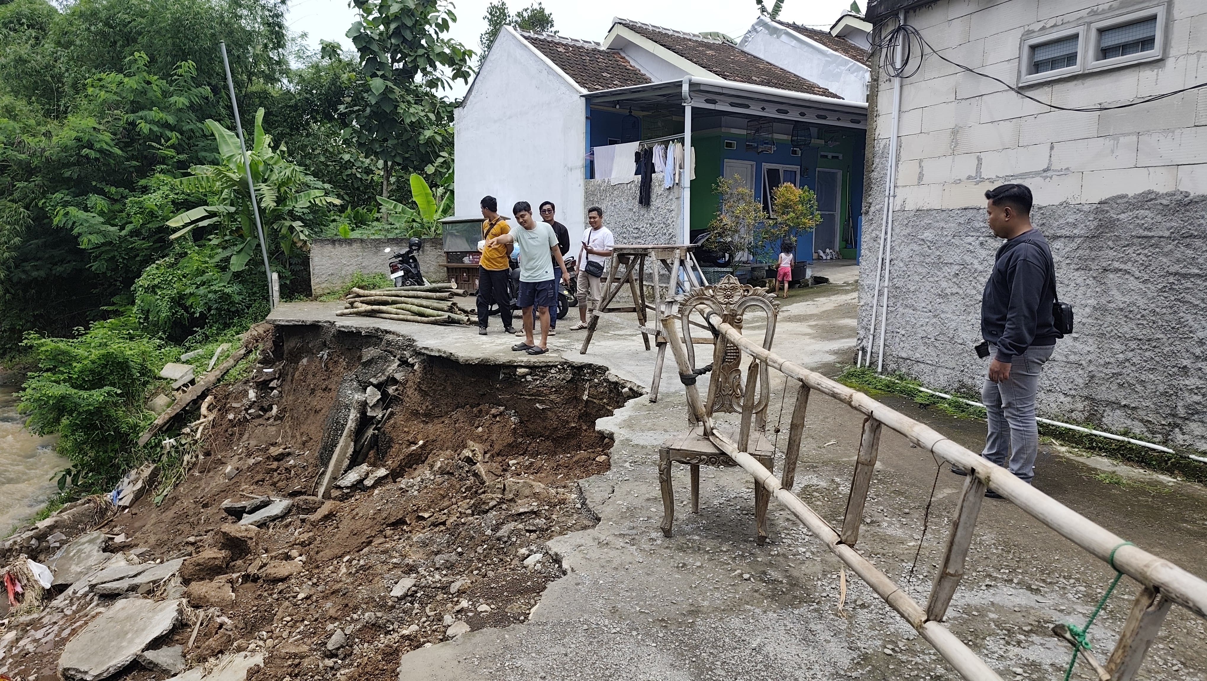AMBLES: Warga menyaksikan tanggul longsor di Perumahan Watu Kebo Raya di Desa Metaraman, Margorejo pada Senin (24/11).
