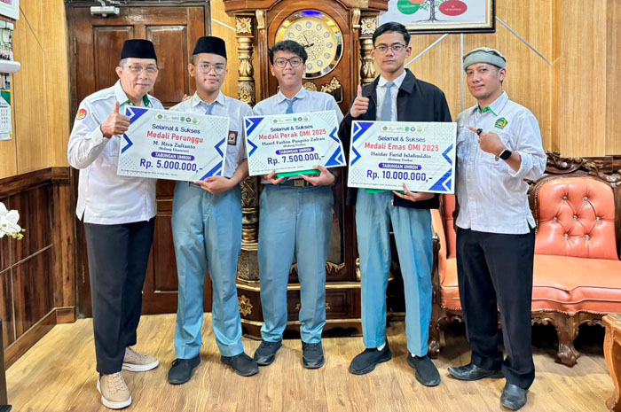 BERNADZAR: Kepala MAN 2 Kudus, Ali Musyafak&nbsp;menyerahkan tabungan umroh kepada tiga peserta didik berprestasi&nbsp;yang meraih medali pada OMI 2025.