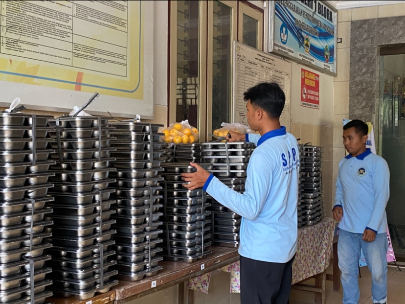PENGEMBALIAN MAKANAN: Tim distribusi MBG dari SPPG Karangjati 1 mengambil makanan yang dikembalikan oleh pihak SPPG Karangjati 1 di SMPN 1 Blora.