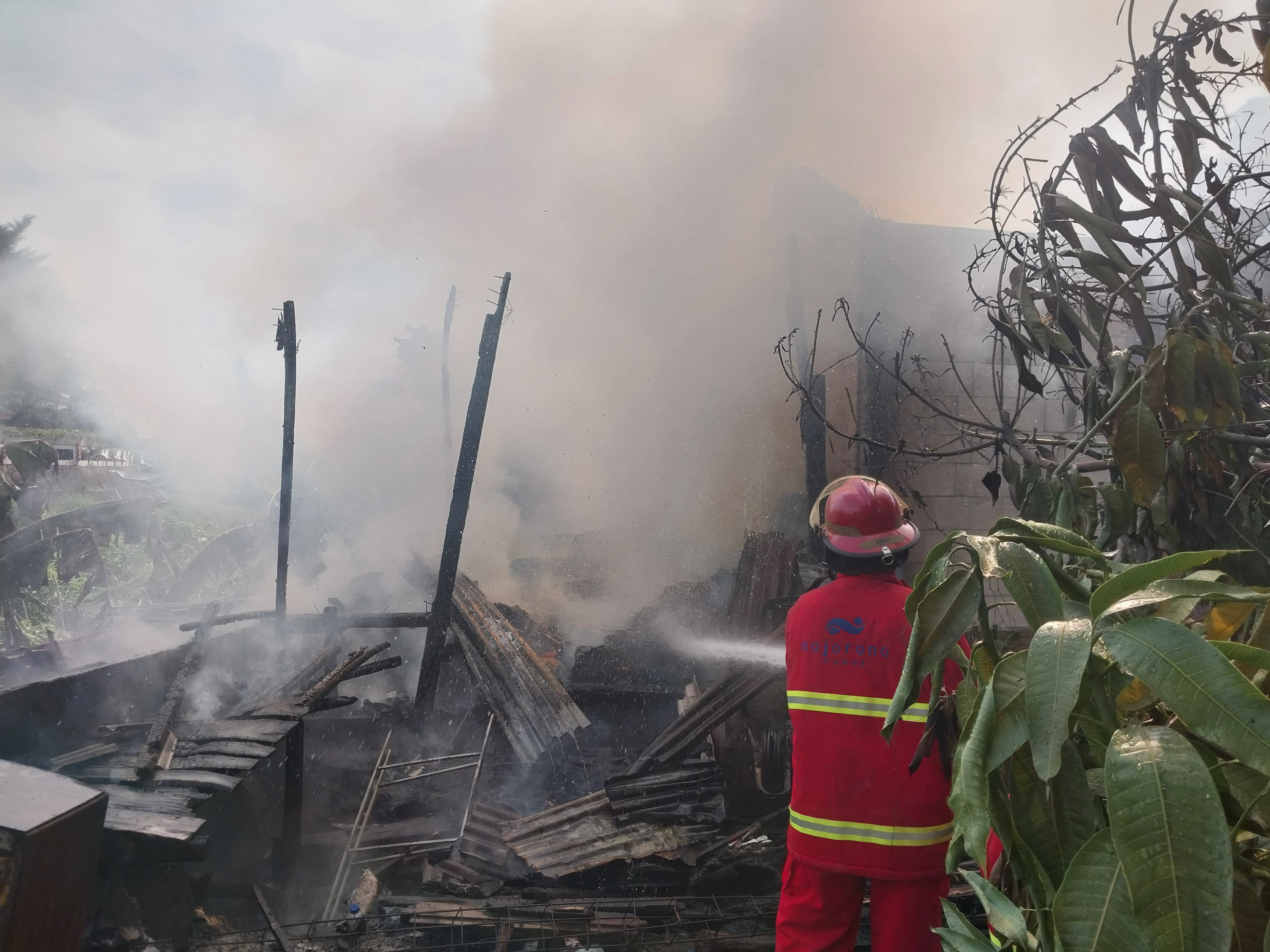 DIPADAMKAN: Tim Damkar berusaha memedamkan api yang melanda rumah di Desa Langgardalem.
